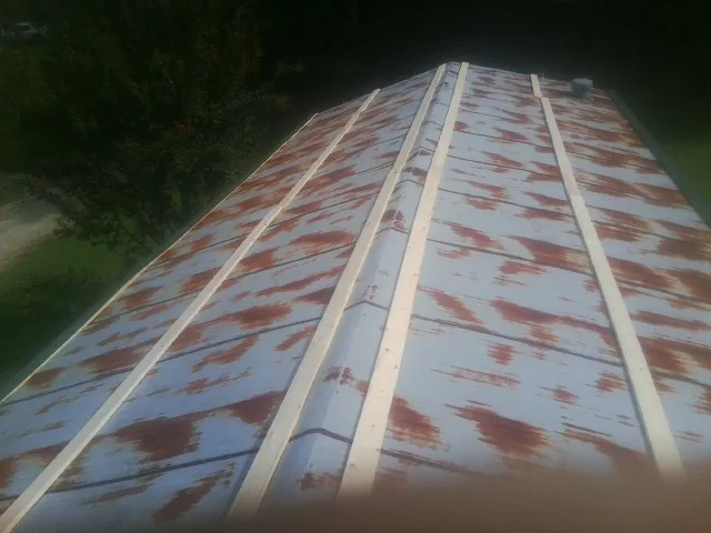 Rusted metal roof panels with new wood purlins before replacement — Storm Damage Roof Repair in Valdese by Roofing Brothers