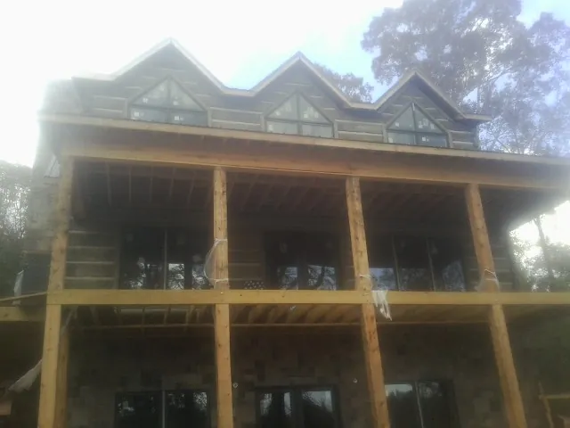 Dormers and porch framing on a large log home under construction — Roof Coating work by our crew in Valdese