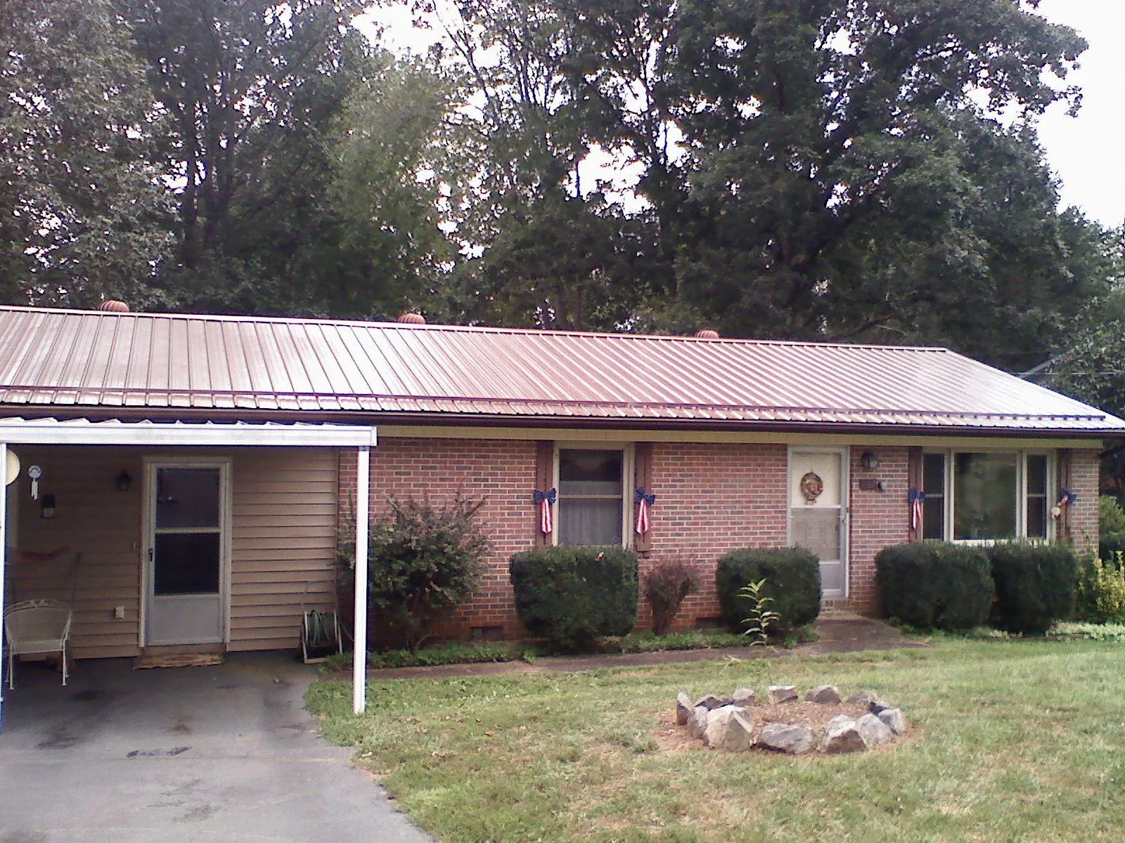 Bronze metal roof and carport on a brick ranch home — Roof Repair work by our crew in Valdese