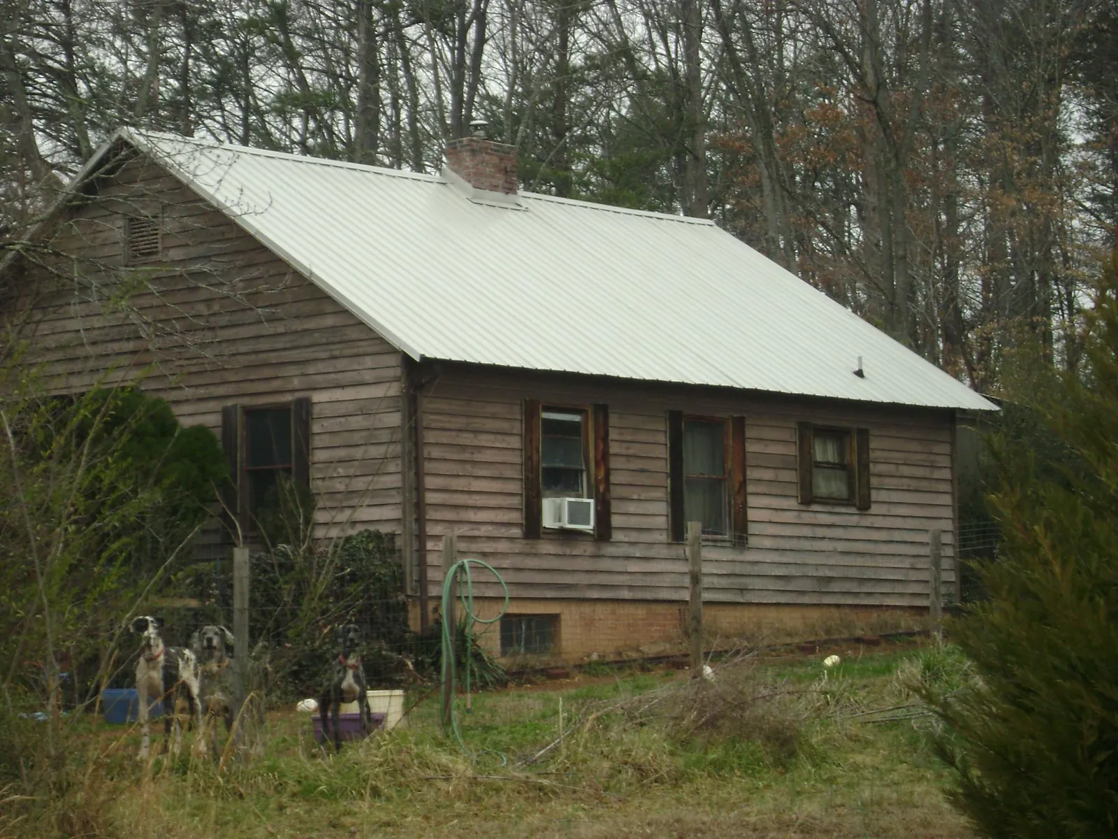 White metal roof on an old wood sided farmhouse, from a Metal Roof Installation job in Valdese